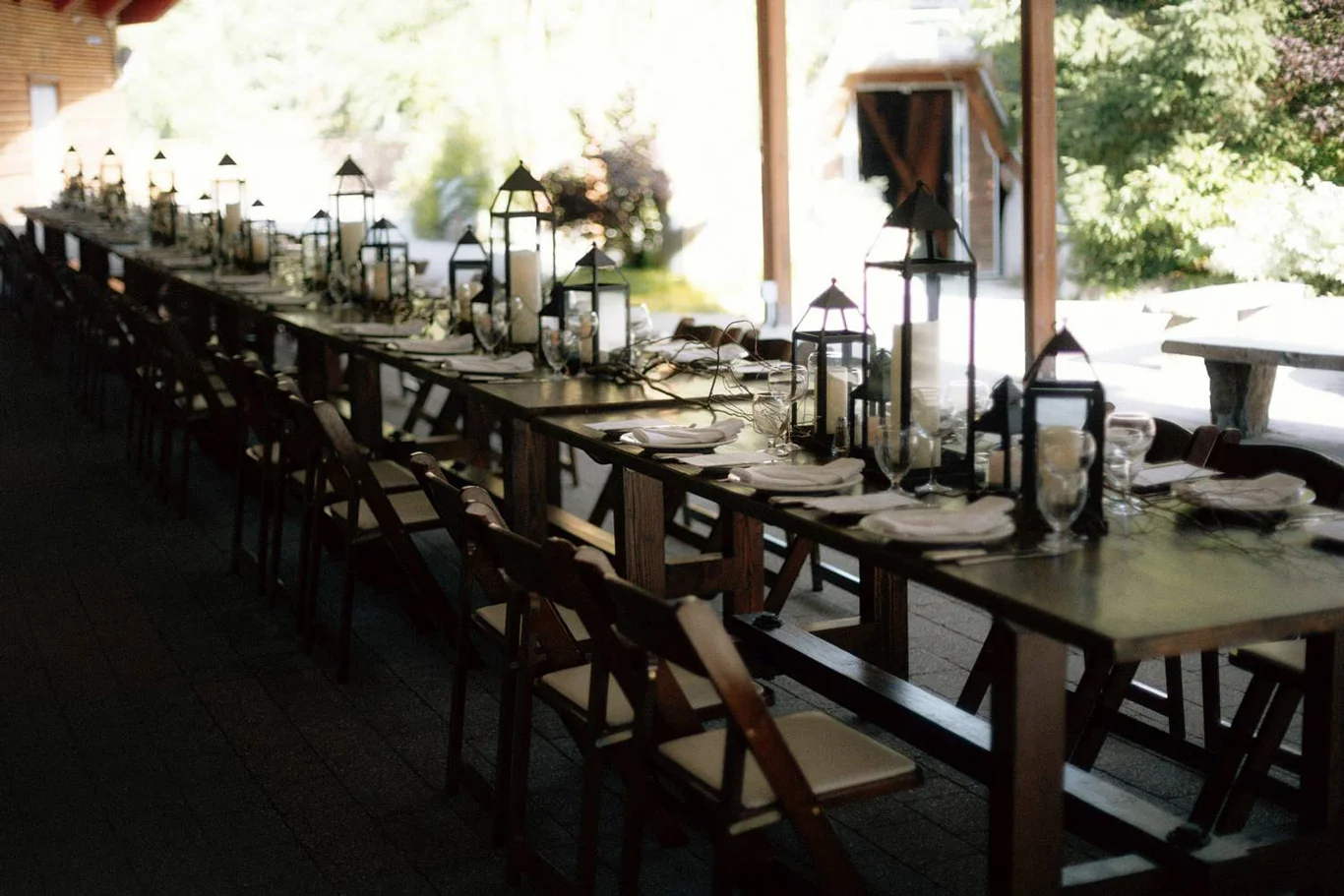 Rustic long dining table setup under covered patio at SLCC