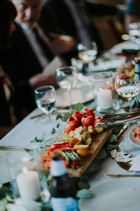 Family-style wedding dining table with shared appetizer platters, candles, and elegant place settings in Whistler.