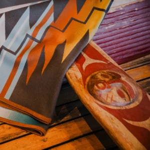 A blanket draped across a traditionally carved canoe